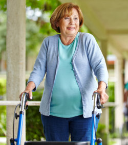 smiling old woman walking with the aid of her crutches