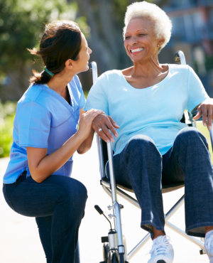 caregiver assisting senior woman and holding her hand