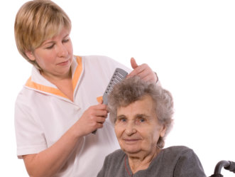 caregiver grooming an elderly woman's hair